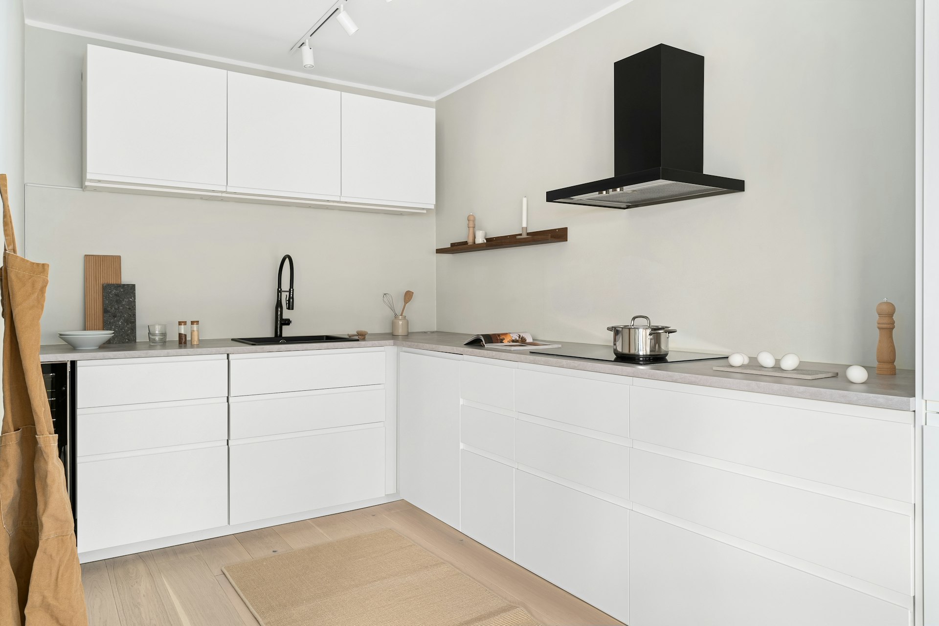 A kitchen with white cabinets and a wooden floor